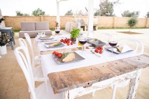 a wooden table with food and wine glasses on it at Casa Paiano in Alezio