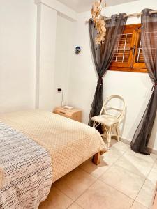 um quarto com uma cama e uma cadeira em Apartment Santana -19 at Beach with Pool, Garage and Lift em Torrevieja