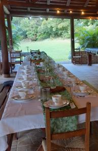 uma longa mesa com pratos e copos em Recanto Hellmann em Gaspar