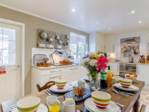 a kitchen with a wooden table with a vase of flowers at 3 bed in Fakenham 85522 in Fakenham