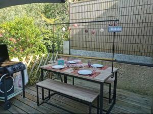 a table and a bench on a patio with a grill at la maison du bonheur in Seignosse +7 photos