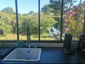a kitchen counter with a sink and a window at la maison du bonheur in Seignosse