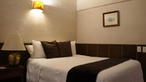 a hotel room with a bed and a lamp at Hotel Casa Blanca in Fresnillo de González Echeverría