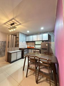 a kitchen with a wooden table and chairs at Blossom - Casa Kayangan Meru Ipoh by GOSWELL in Ipoh