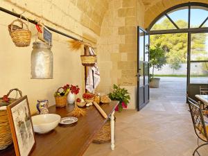 a kitchen with a wooden table and a large window at Masseria La Millenaria in San Foca
