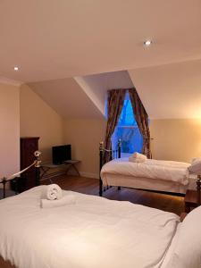 1 dormitorio con 2 camas y ventana en Sheil Suites, en Liverpool