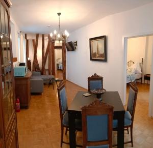 a dining room and living room with a table and chairs at Historischer Winzerverein Boutique B&B in Senheim