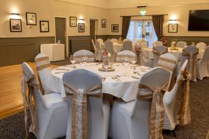 - une salle de banquet avec des tables et des chaises blanches dans l'établissement Charnwood Arms, à Coalville