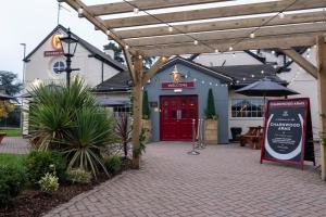 um edifício com uma porta vermelha e uma placa à frente em Charnwood Arms em Coalville