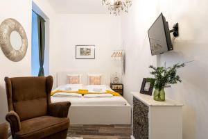 1 dormitorio con 1 cama, 1 silla y TV en HM • Practical 1BR Flat by Center, en Viena