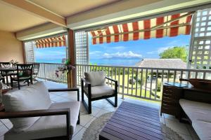 a screened in porch with a view of the ocean at Kahaia beach home with pool amazing seafront black sand beach and reef in Paea