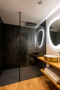 een badkamer met een glazen douche en een wastafel bij LesSecretsRooms Loveroom -Angers in Angers