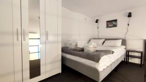 a white bedroom with a bed and a table at Eroilor Art Studio in Cluj-Napoca