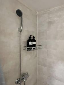 a shower with two bottles on a shelf in a bathroom at Eroilor Art Studio in Cluj-Napoca