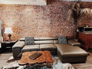 a living room with a brown couch and a brick wall at Hotel Kutuma in Montreal