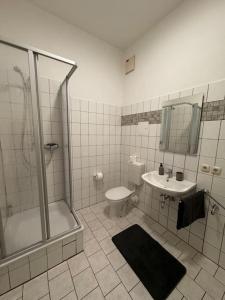 a bathroom with a shower and a toilet and a sink at Wohnung im Zentrum 2 in Magdeburg