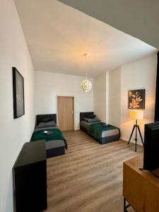 a room with two beds and a television in it at Wohnung im Zentrum 2 in Magdeburg