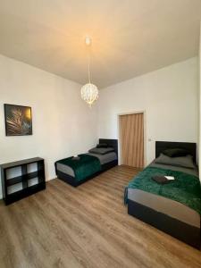 1 Schlafzimmer mit 2 Betten und einem Kronleuchter in der Unterkunft Wohnung im Zentrum 2 in Magdeburg