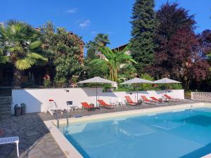 einen Pool mit Stühlen und Sonnenschirmen in der Unterkunft casaMargò in Castellamonte