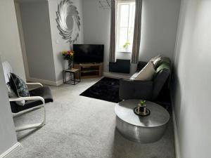 a living room with a couch and a table at Lowther House -2 Bed Apartment in Whitehaven