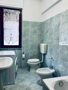 a bathroom with a toilet and a sink and a window at Francesca Appartamento con giardino in Levanto