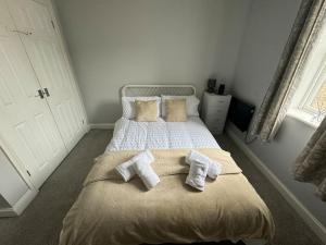 a bedroom with a bed with two towels on it at Lowther House -2 Bed Apartment in Whitehaven