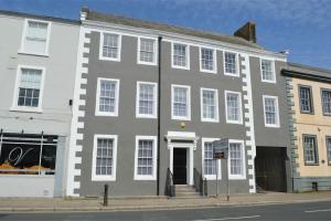 a large gray building on the corner of a street at Lowther House -2 Bed Apartment in Whitehaven