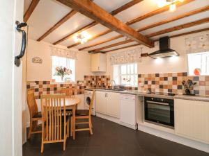a kitchen with a table and a dining room at Toad Cottage in Matlock