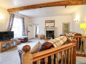 a living room with a couch and a fireplace at Toad Cottage in Matlock