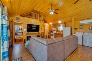 a living room with a couch and a ceiling fan at Riverfront Cabin Near Smoky Mountain National Park in Walland