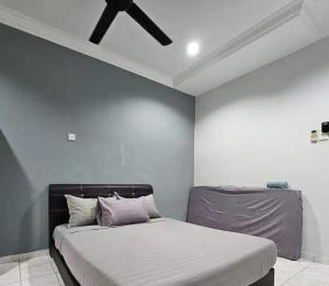 Tambun Sunway Homestay في تامبون: غرفة نوم بسرير ومروحة سقف