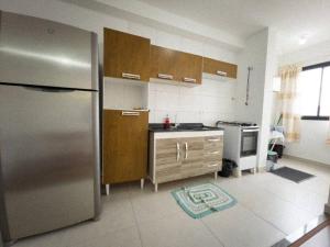 a kitchen with a stainless steel refrigerator and a stove at Apto Novo Prox. Hosp. Paraná Wi-Fi Fibra - AZ401 in Maringá +2 photos