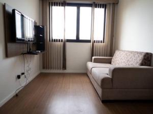 uma sala de estar com um sofá e uma televisão de ecrã plano em Apto Novo Prox. Hosp. Paraná Wi-Fi Fibra - AZ401 em Maringá