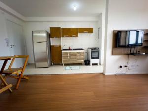 eine Küche mit einem Kühlschrank aus Edelstahl und einem Tisch in der Unterkunft Apto Novo Prox. Hosp. Paraná Wi-Fi Fibra - AZ401 in Maringá