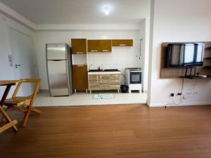 a kitchen with a stainless steel refrigerator and a table at Apto Novo Prox. Hosp. Paraná Wi-Fi Fibra - AZ401 in Maringá