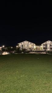 a large building at night with a green field at شاليه ومنتجع ملك in Jazan