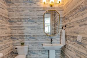a bathroom with a sink and a mirror at Luxury Beach House Glow in dark golf Game Room in Bolivar Peninsula +56 photos