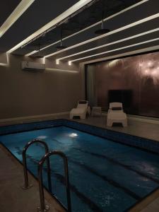 una gran piscina con 2 sillas y una mesa en شاليه ومنتجع ملك, en Jazan