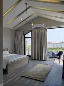 een slaapkamer met een bed en een groot raam bij شاليه ومنتجع ملك in Jazan