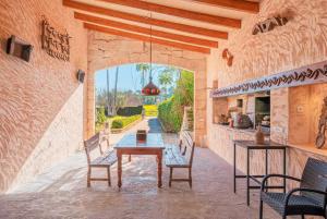 an outdoor patio with a table and chairs and an archway at Es Rafal in Santa Margalida