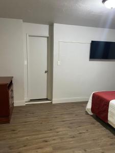 ein leeres Zimmer mit einem Bett und einer Tür in der Unterkunft Arizona 9 Motor Hotel in Williams