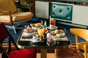een dienblad met ontbijtproducten op een tafel in een kamer bij Ruby Bea Hotel Florence in Florence