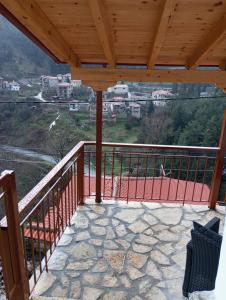 a balcony with a wooden roof with a view of a mountain at family home in Dimitsana