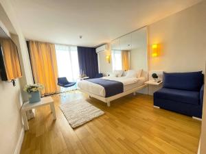 ein Hotelzimmer mit einem Bett und einem blauen Sofa in der Unterkunft KING DAVID & Orbi City Batumi in Batumi