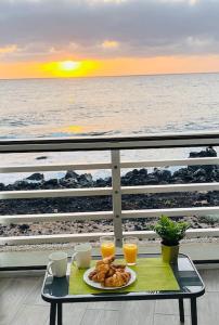 un tavolo con un piatto di cibo e due bicchieri di succo d'arancia di La Terraza del Mar a Puertito de Güímar