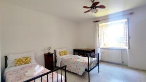 1 dormitorio con 2 camas y ventana en Aragonite Azzurra Casa Vacanza, en Gonnesa
