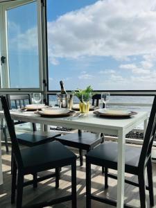 un tavolo bianco con sedie e bicchieri da vino su un balcone di La Terraza del Mar a Puertito de Güímar