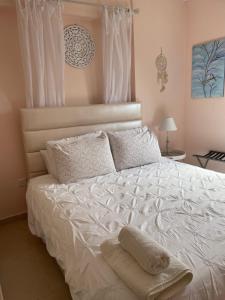 sypialnia z białym łóżkiem z 2 poduszkami w obiekcie Mariliz w Larnace