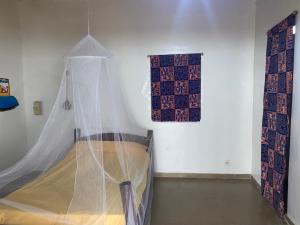 Ngalou SessèneChambre en bord de mer …(pied dans l’eau)的带床和蚊帐的卧室