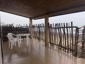 Ngalou SessèneChambre en bord de mer …(pied dans l’eau)的俯瞰大海的阳台配有桌椅 更多3张照片